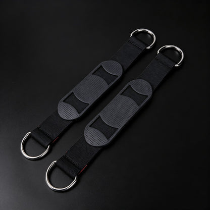 Two black adjustable shoulder straps with silver metal D-rings, displayed diagonally on a dark black background.